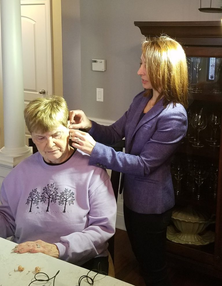 Dr. Corbett fitting a patient with a hearing aid